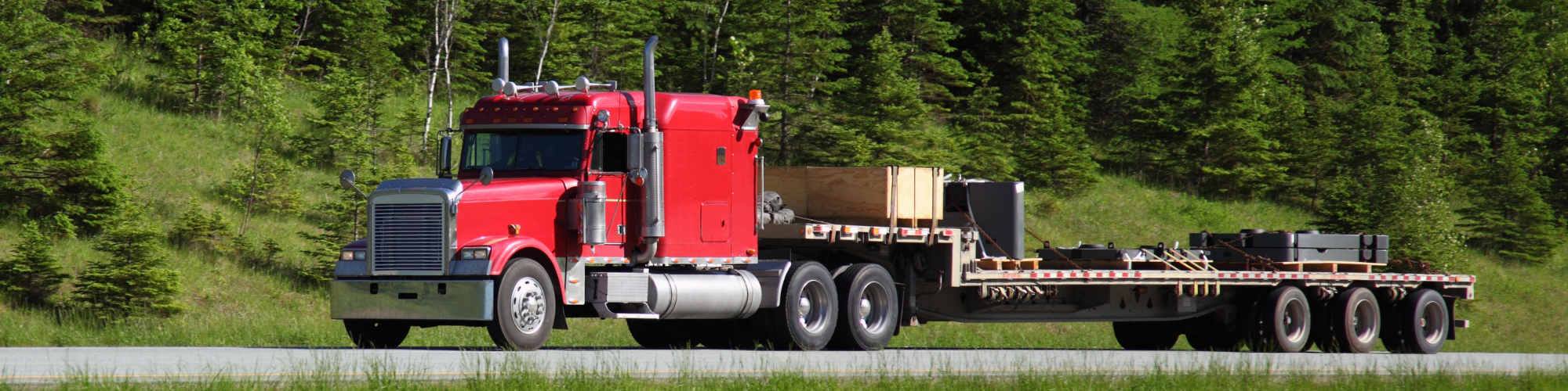 red semi-truck hauling equipment 